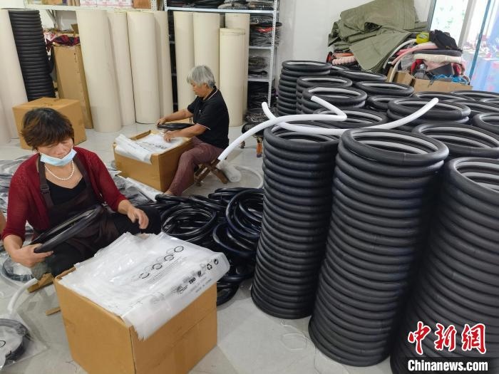 圖為村民在汽車飾品企業(yè)生產(chǎn)車間中工作?！巫雍?攝