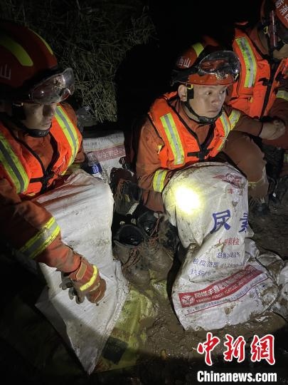 短暫修整期間，消防員脫掉鞋襪，用編織袋套住腿腳保暖。　閆旭輝 攝