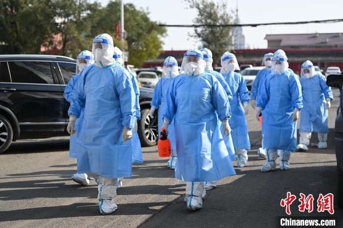 圖為醫(yī)務(wù)人員在封閉小區(qū)做防控工作?！⑽娜A 攝