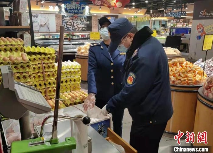 圖為疫情期間，甘肅嘉峪關市場監(jiān)管局工作人員檢查蔬菜市場?！?柴佳楠 　攝