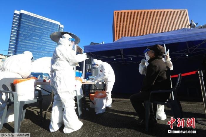 資料圖：韓國首爾，醫(yī)務(wù)人員對市民進行新冠病毒檢測。