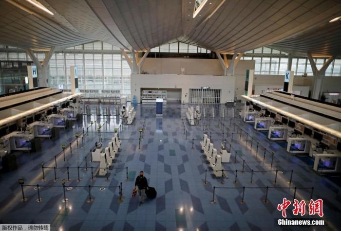 資料圖：日本東京，東京國(guó)際機(jī)場(chǎng)，一名乘客在國(guó)際航班航站樓的登機(jī)區(qū)。