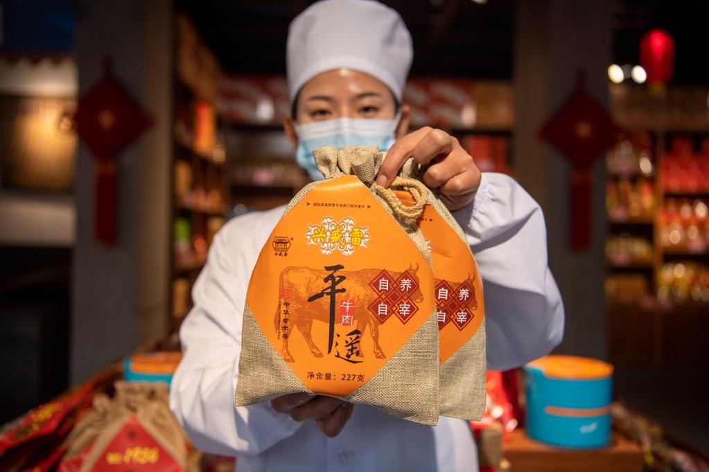 1月27日，在平遙古城南大街的一家平遙牛肉店內(nèi)，工作人員展示一款牛肉產(chǎn)品。新華社記者 楊晨光 攝