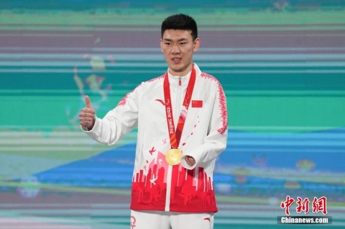 3月6日，梁景怡在延慶頒獎(jiǎng)廣場(chǎng)領(lǐng)獎(jiǎng)臺(tái)上豎起大拇指。當(dāng)日，在國(guó)家高山滑雪中心舉行的北京2022年冬殘奧會(huì)殘奧高山滑雪男子超級(jí)大回轉(zhuǎn)—站姿決賽中，中國(guó)選手梁景怡奪得冠軍。 <a target='_blank' href='/'>中新社</a>記者 楊華峰 攝