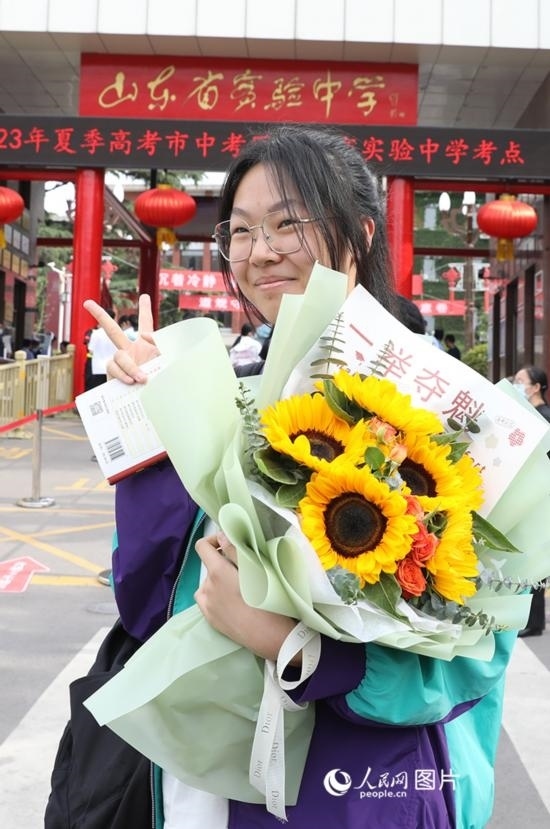 6月7日高考首日，山東67萬考生走進(jìn)考場，拼搏逐夢。在山東省實(shí)驗(yàn)中學(xué)考點(diǎn)，考生進(jìn)考場前手捧向日葵花拍照留念，寓意“一舉奪魁”。人民網(wǎng)記者 劉祺攝