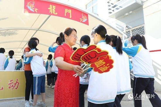 6月7日一早，雄安新區(qū)安新中學(xué)老師在給同學(xué)們加油鼓勁兒。人民網(wǎng) 李兆民攝
