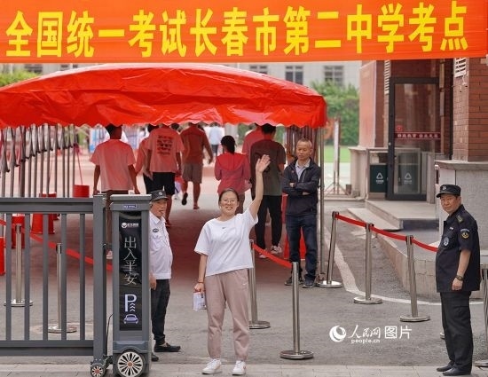 6月7日，在長春市第二中學(xué)考點(diǎn)，一名考生信心滿滿進(jìn)入考場，并與家長揮手致意。人民網(wǎng)記者 李洋攝