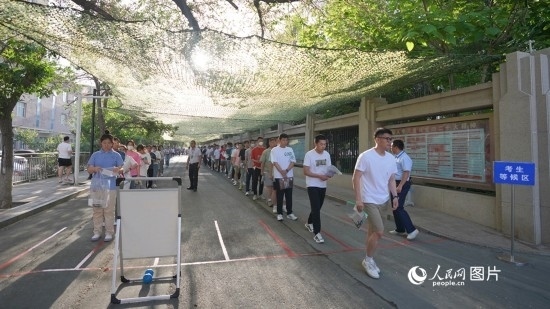 6月7日，烏魯木齊市第七十中學(xué)門口，考生們有序進(jìn)入考場。人民網(wǎng) 李欣洋攝