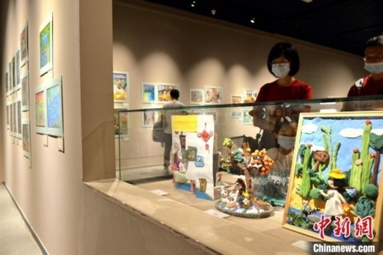 圖為家長帶著孩子參觀展覽。呂明 攝