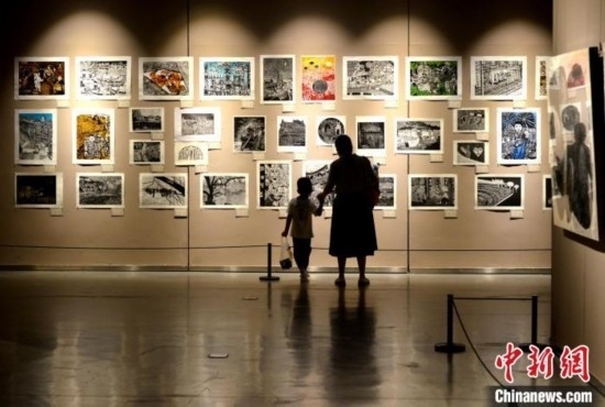 圖為家長帶著孩子參觀展覽。呂明 攝