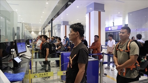 6月13日，乘坐中老鐵路國際旅客列車的旅客在磨憨邊檢大廳排隊候檢。李揚(yáng) 攝