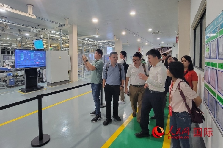 廣汽埃安工作人員向外媒記者進(jìn)行介紹。人民網(wǎng) 寧玉瑛攝