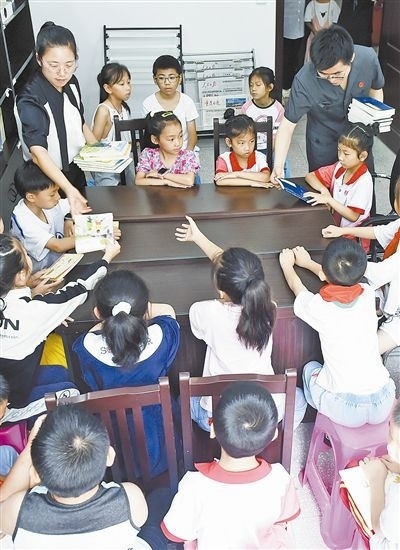  圖④：法院干警為留守兒童發(fā)放暑假讀物。