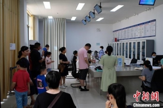 圖為在戶籍辦證廳內排隊等待的家長和孩子。劉俊聰 攝