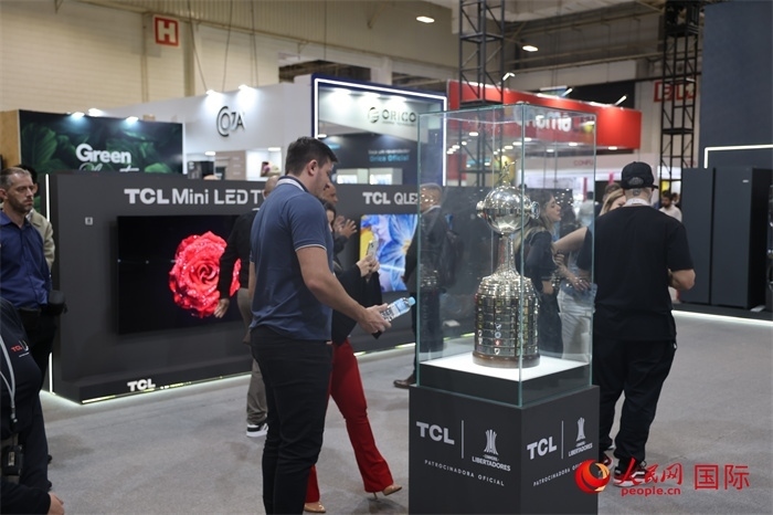 參觀者在TCL展臺前觀看南美解放者杯獎杯，據(jù)介紹，TCL是南美解放者杯（2023—2026賽季）全球官方合作伙伴。（人民網(wǎng)記者 時元皓攝）
