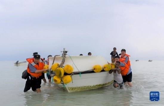 7月21日，中國海軍“和平方舟”號(hào)醫(yī)院船醫(yī)護(hù)人員涉水登島，前往基里巴斯一診療點(diǎn)。新華社記者 黎云 攝