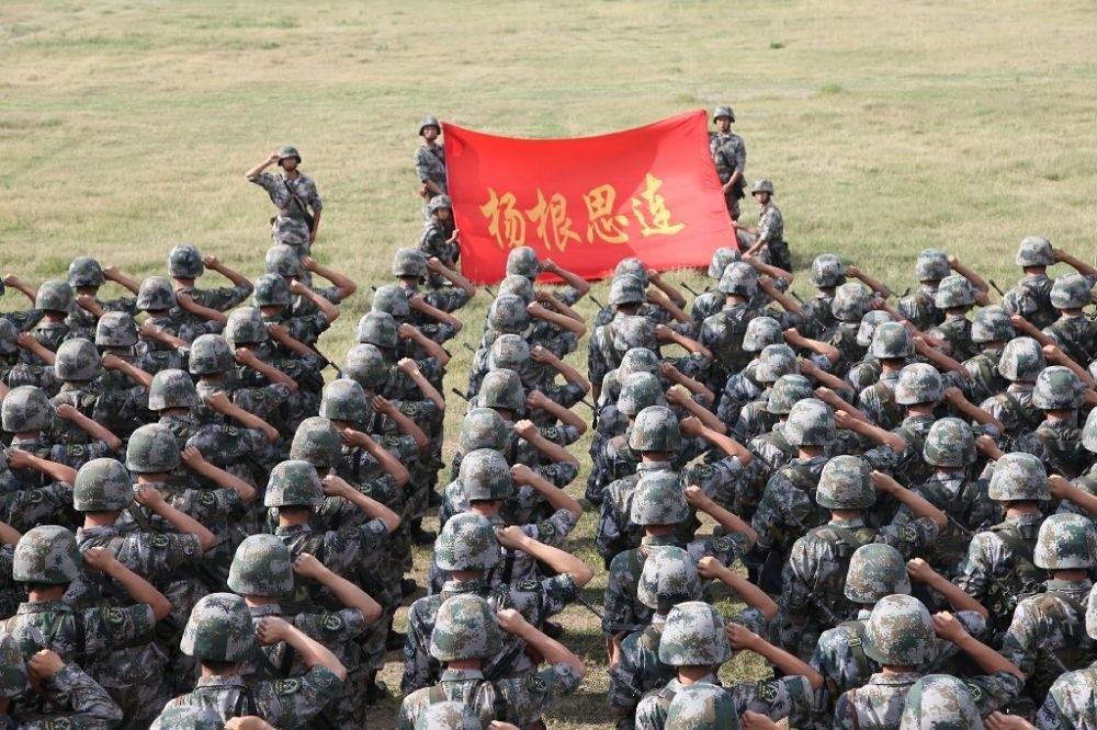 ↑“楊根思連”官兵執(zhí)行任務(wù)前向連旗宣誓（資料照片）。新華社發(fā)