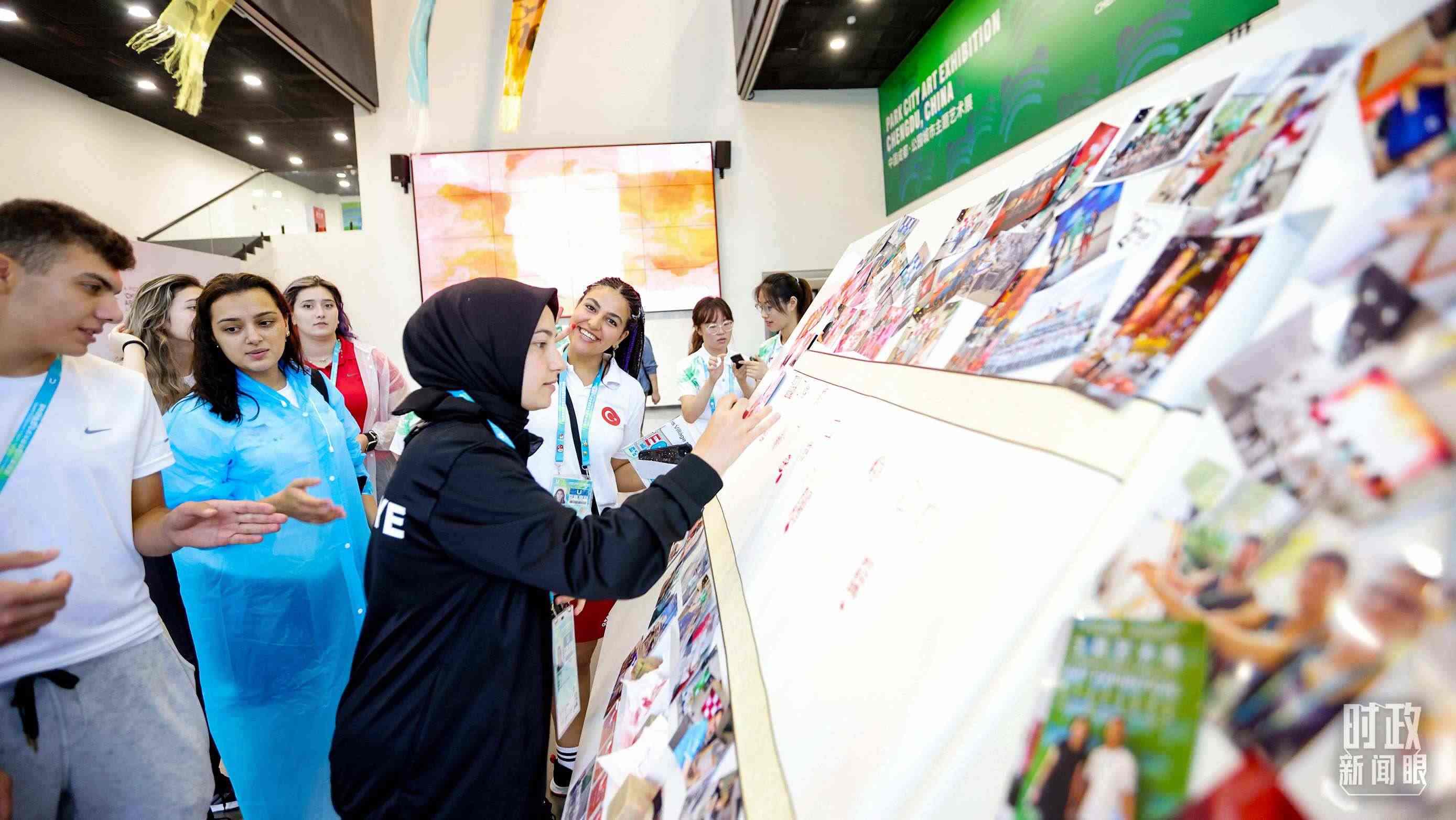 各國青年運動員正在參觀成都大運村內(nèi)的“雪山下的公園城市，煙火里的幸福成都”主題藝術(shù)展。（總臺央視記者魏幫軍拍攝）