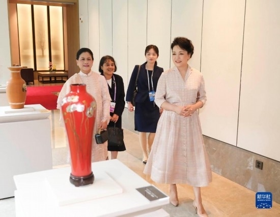 7月27日下午，國家主席習近平夫人彭麗媛在四川成都會見陪同印度尼西亞總統(tǒng)佐科來華出席第31屆世界大學生夏季運動會開幕式并訪華的總統(tǒng)夫人伊莉亞娜。這是彭麗媛和伊莉亞娜欣賞成都特色非遺工藝品。新華社記者 丁林 攝