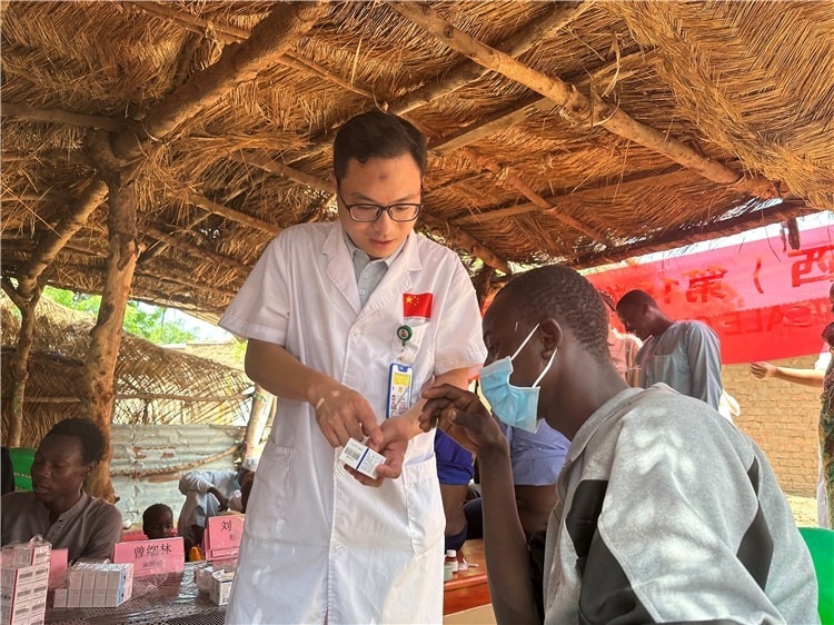 圖為南昌大學(xué)第一附屬醫(yī)院病理科主治醫(yī)師張振東為村民解說藥品使用方法。中國(guó)駐乍得醫(yī)療隊(duì)供圖