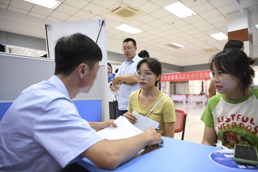 2023年7月29日，“揚(yáng)就業(yè)之帆，啟夢(mèng)想之旅”2023年寧夏（銀川）離校未就業(yè)高校畢業(yè)生招聘會(huì)在寧夏（銀川）人力資源服務(wù)產(chǎn)業(yè)園舉行。求職者（右）在招聘會(huì)現(xiàn)場(chǎng)與用人單位交流。新華社記者 馮開(kāi)華 攝