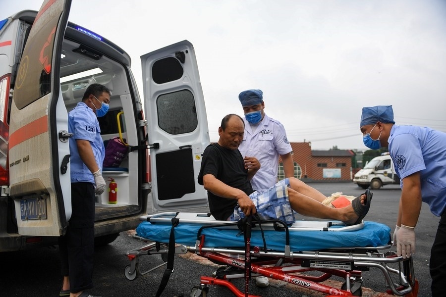 8月1日，在北京市門頭溝區(qū)妙峰山鎮(zhèn)妙峰山民族學(xué)校臨時(shí)安置點(diǎn)，北京急救中心工作人員在轉(zhuǎn)運(yùn)一名受傷村民。新華社記者 鞠煥宗 攝