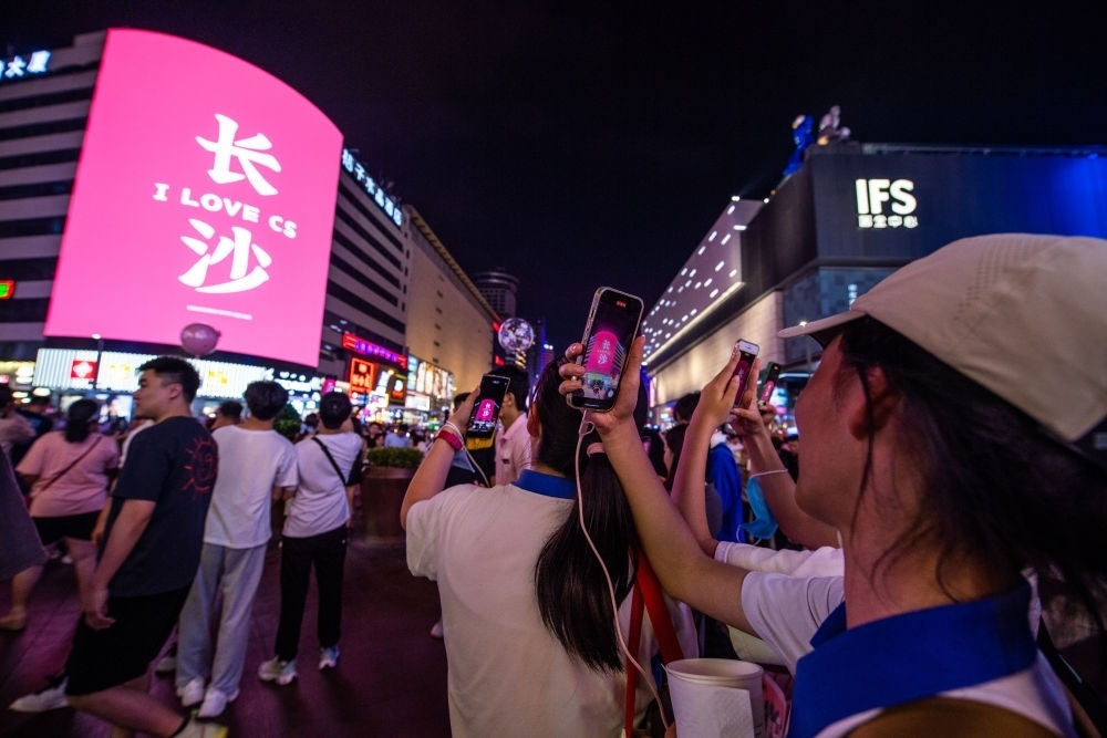  游客在長(zhǎng)沙市天心區(qū)黃興路步行街打卡、拍照（6月7日攝）。新華社記者 陳思汗 攝