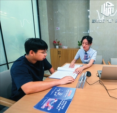 在杭州市臨安區(qū)政務服務中心的“為企服務中心”，黨員志愿者（右）解答企業(yè)主的疑問（2023年7月7日攝）。徐昱攝/本刊