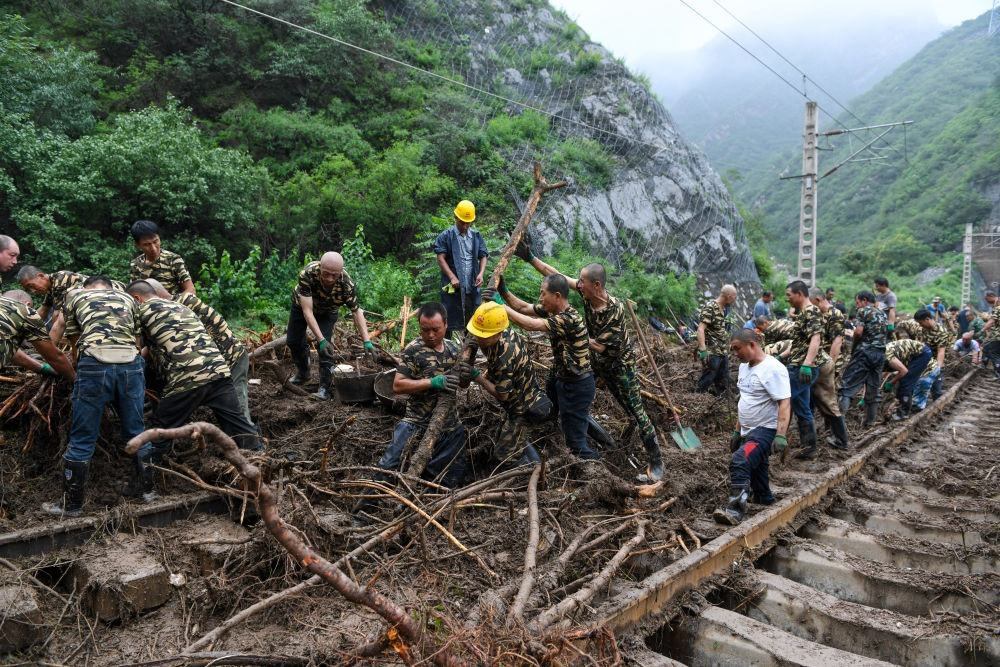8月1日，在北京市門頭溝區(qū)水峪嘴村附近一段被阻斷的鐵路線上，中鐵六局工作人員在清理軌道上的雜物，全力恢復(fù)交通。新華社記者 鞠煥宗 攝