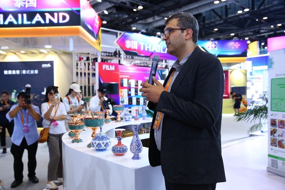 9月1日，參展商在國家會議中心向媒體記者介紹展臺信息。新華社記者 孫瑋彤 攝