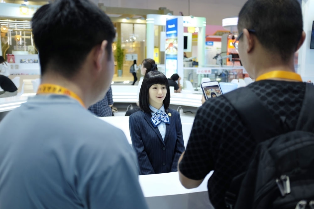 9月1日，媒體記者在國家會議中心與服務(wù)機(jī)器人互動。新華社記者 劉夢琪 攝