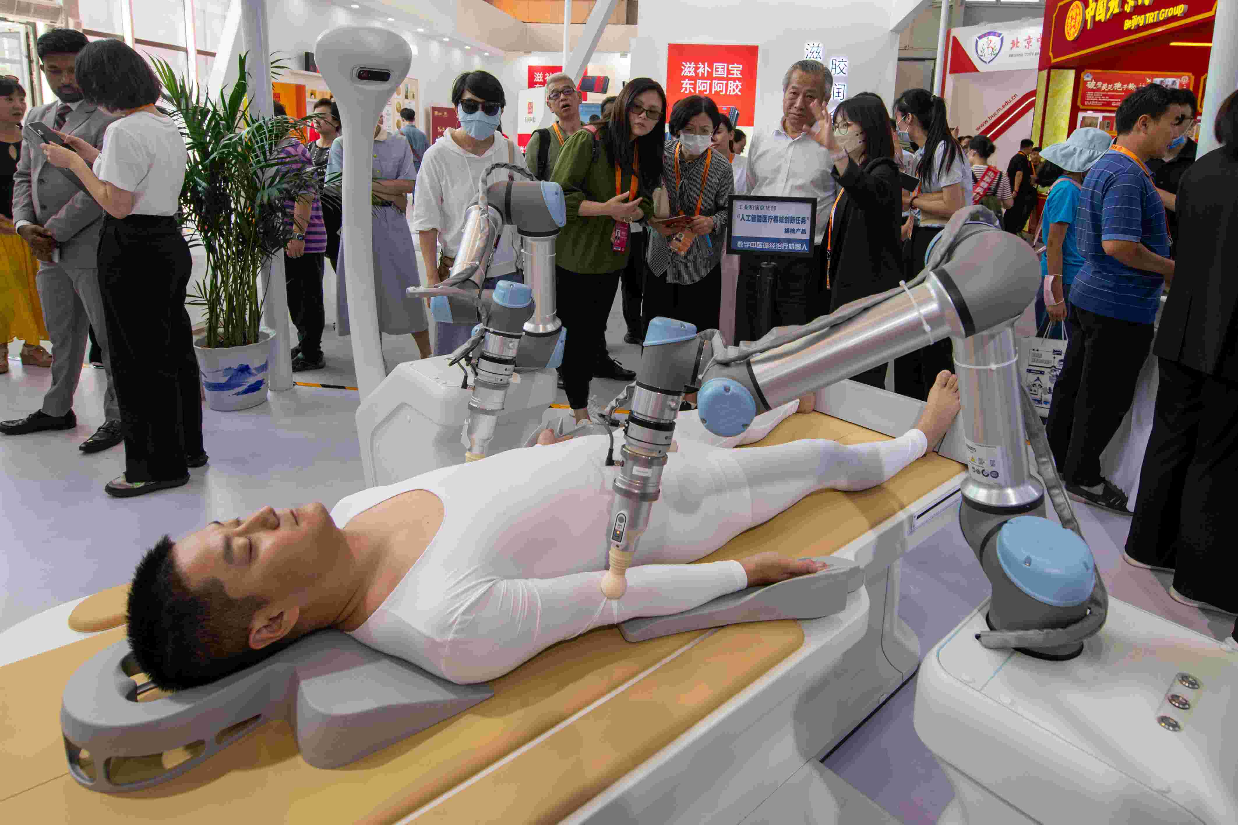 在位于首鋼園的健康衛(wèi)生服務(wù)展區(qū)，觀眾正在參觀數(shù)字中醫(yī)循經(jīng)治療機(jī)器人。人民網(wǎng)記者 翁奇羽攝