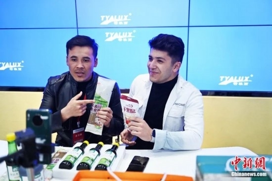 2023年3月，甘肅省慶陽(yáng)市環(huán)縣電商創(chuàng)業(yè)孵化基地內(nèi)，來(lái)自蘭州文理學(xué)院的塔吉克斯坦留學(xué)生正在協(xié)助主播直播帶貨當(dāng)?shù)剞r(nóng)特產(chǎn)品。李亞龍 攝