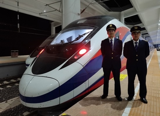 劉銀能（右一）與中國師父鄔俊鴻在動(dòng)車組前合影。受訪者供圖