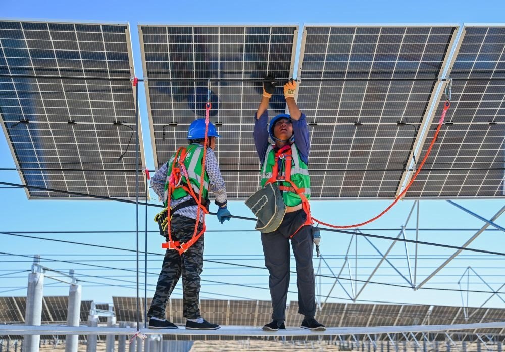 2023年7月22日，工人在位于內(nèi)蒙古杭錦旗庫布其沙漠億利生態(tài)示范區(qū)的蒙西基地庫布其200萬千瓦光伏治沙項目工地安裝光伏板。新華社記者 劉磊 攝