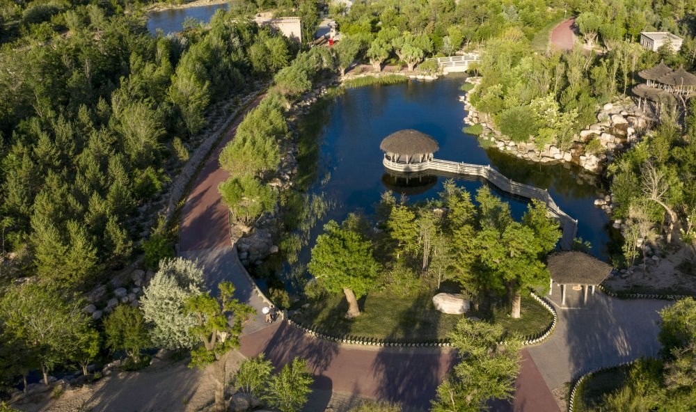 坐落在寧夏銀川市賀蘭山腳下的賀蘭山運動休閑公園（2021年5月27日攝，無人機照片）。這里曾是一片砂石采礦塌陷區(qū)，當(dāng)?shù)赝ㄟ^植被景觀再造、水系建設(shè)、現(xiàn)代管網(wǎng)鋪建等手段，重新利用廢石、廢坑及各類廢棄建筑材料，把這里變成一座免費開放的主題公園。新華社記者 馮開華 攝