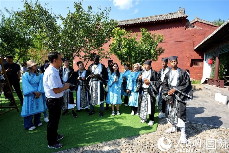 圖為選手們聽導(dǎo)游講解。人民網(wǎng) 盧鵬宇攝