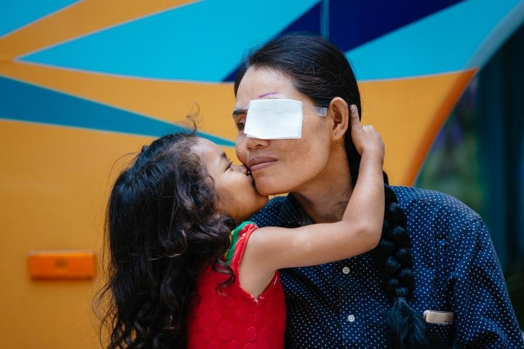 2019年3月15日，在柬埔寨磅湛省醫(yī)院，即將接受白內(nèi)障手術(shù)的患者孫美樂(lè)接受女兒的親吻祝福。在接受了中國(guó)醫(yī)療隊(duì)的白內(nèi)障義診手術(shù)后，她的視力逐步恢復(fù)，生活有了新的光明和希望。