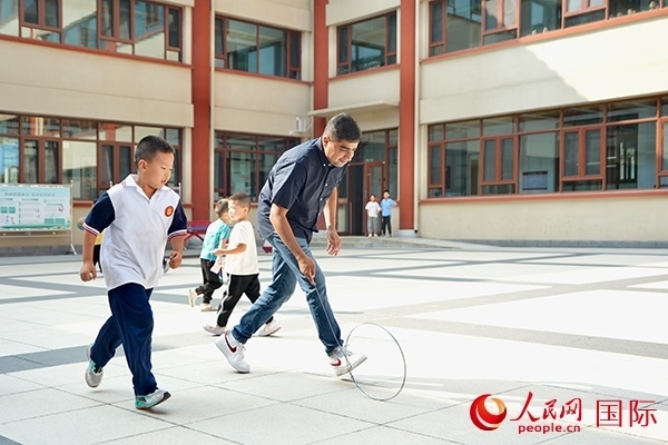 來自巴基斯坦的沙杰在滾鐵環(huán)。人民網(wǎng) 盧鵬宇攝