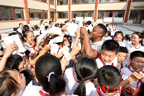 孩子們和選手互動(dòng)簽名。人民網(wǎng) 盧鵬宇攝