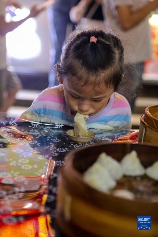 9月27日，小朋友在南翔小籠長街宴上品嘗南翔小籠。