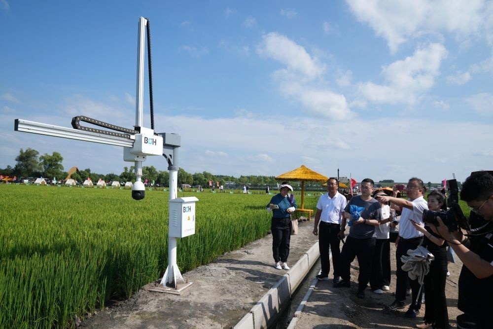 在北大荒集團(tuán)閆家崗農(nóng)場(chǎng)有限公司農(nóng)業(yè)現(xiàn)代化示范區(qū)，工作人員在介紹利用數(shù)字技術(shù)的葉齡診斷儀（2023年8月10日攝）。新華社記者 王建威 攝