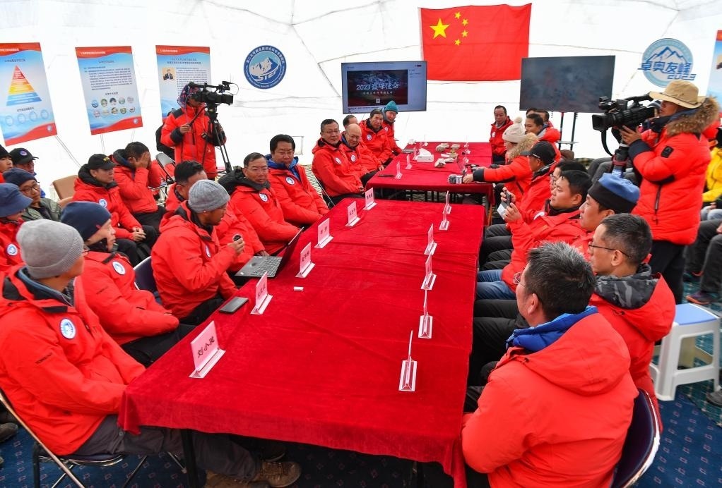 海拔4950米的卓奧友峰科考大本營，科考隊員趙華標（手拿麥克風看電腦者）在宣讀剛剛接收到的頂峰氣象觀測數(shù)據(jù)，這標志著峰頂自動氣象站架設成功，成功傳回觀測數(shù)據(jù)（10月1日攝）。新華社記者晉美多吉 攝