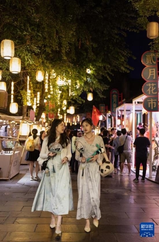 在成都寬窄巷子，兩位來(lái)自安徽的游客在新“十二月市”街區(qū)游覽（9月29日攝）。