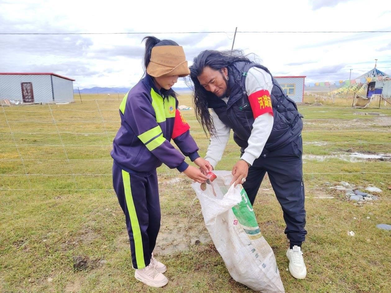 玉樹州稱多縣珍秦鎮(zhèn)河湖志愿者才培和他女兒更求拉毛在清掃垃圾。受訪者供圖
