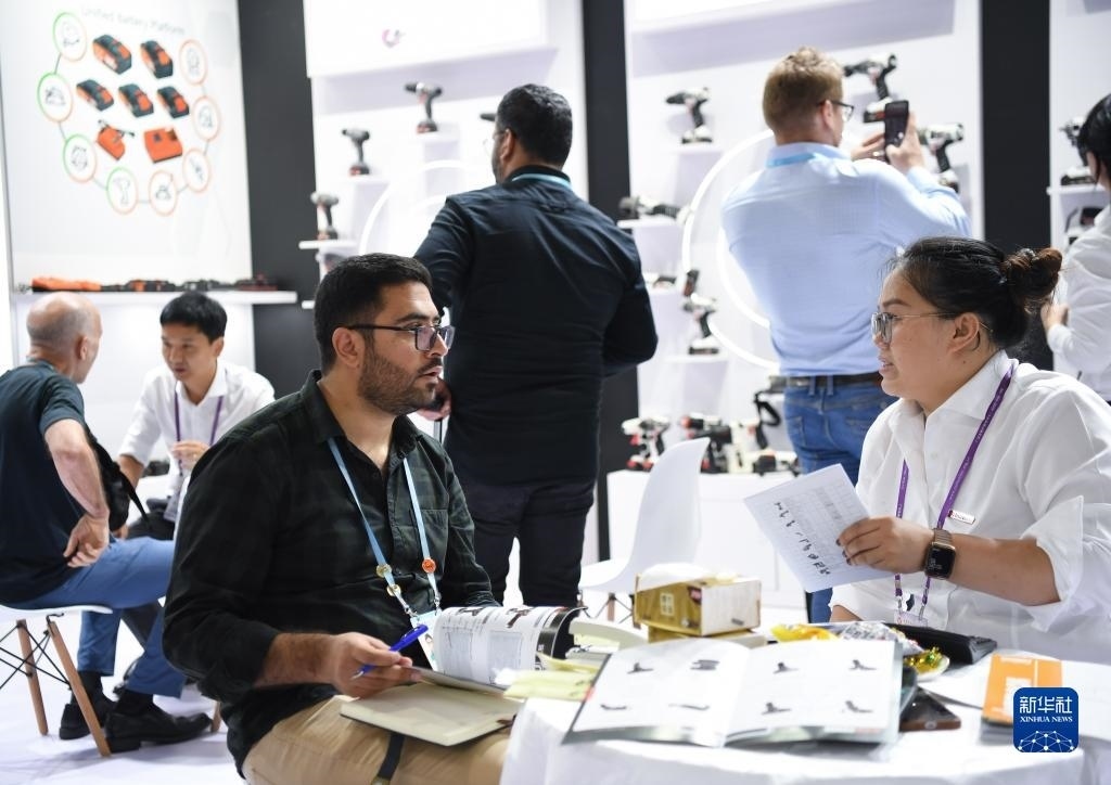 10月15日，在一家電動工具展臺，外國采購商在洽談業(yè)務(wù)。新華社記者 鄧華 攝