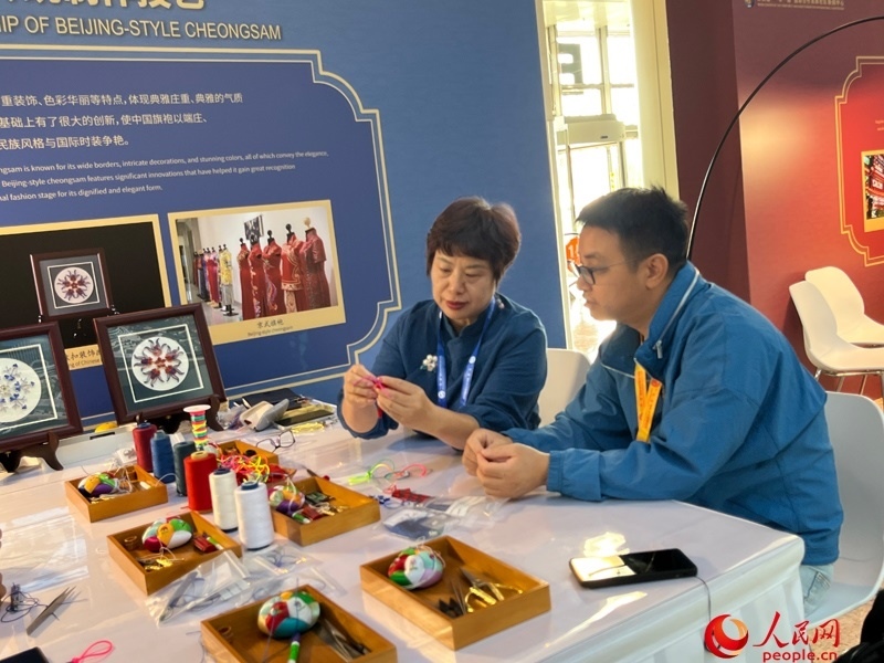 記者在新聞中心非遺傳承人展區(qū)進(jìn)行體驗(yàn)。人民網(wǎng)記者 杜燕飛攝