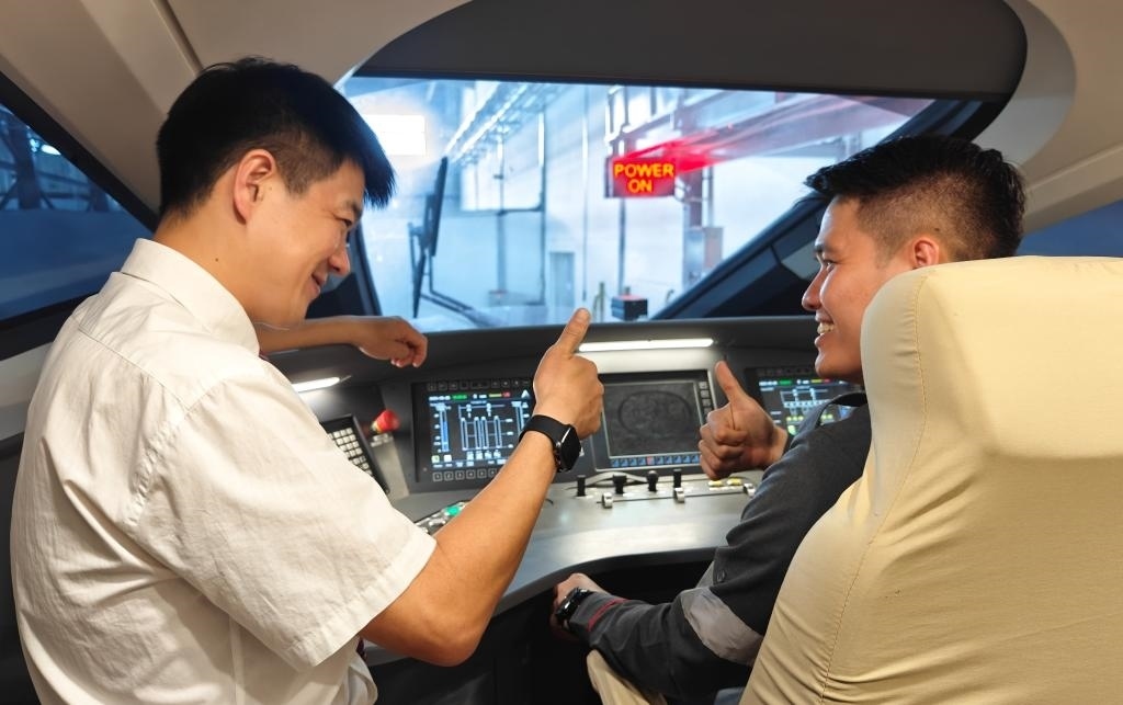 8月25日，在印度尼西亞萬(wàn)隆的雅萬(wàn)高鐵德卡魯爾動(dòng)車所內(nèi)，中國(guó)師傅穆振（左）在向印尼火車司機(jī)塞蒂亞萬(wàn)講解動(dòng)車組出庫(kù)前的上電作業(yè)。