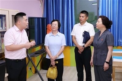 圖③：“小公民法律課堂”開講前，全國人大代表殷其龍（右二）、重慶市人大代表李自玲（左二）聽取楊家坪中學負責人關于未成年人思想教育工作情況的介紹。