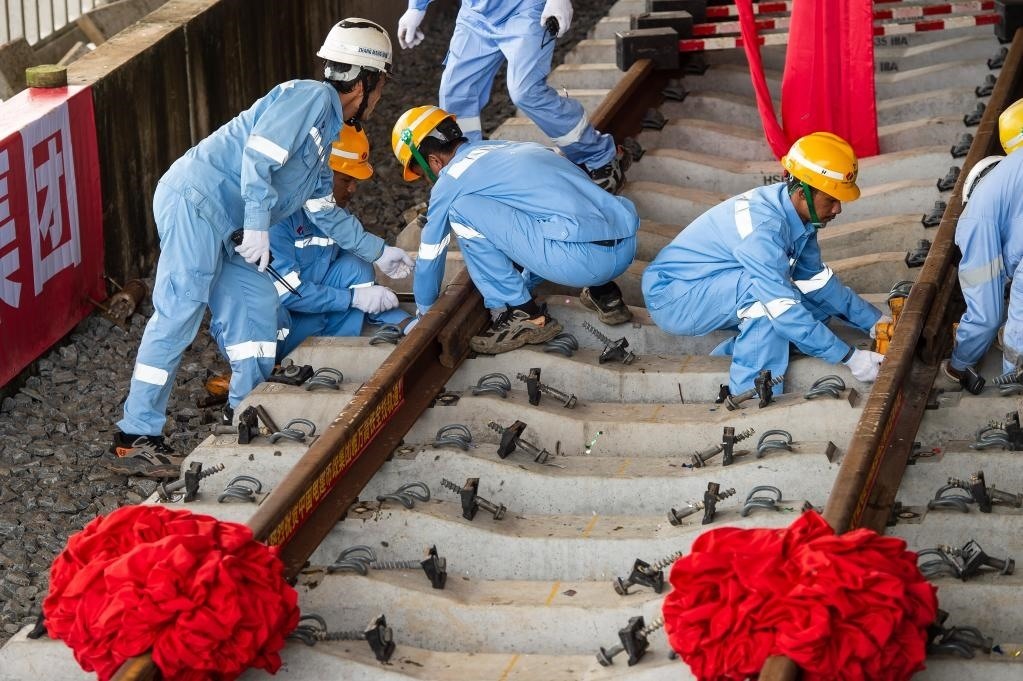 3月31日，在印度尼西亞雅加達(dá)雅萬(wàn)高鐵哈利姆車站，工人鋪設(shè)雅萬(wàn)高鐵全線最后一根鋼軌。